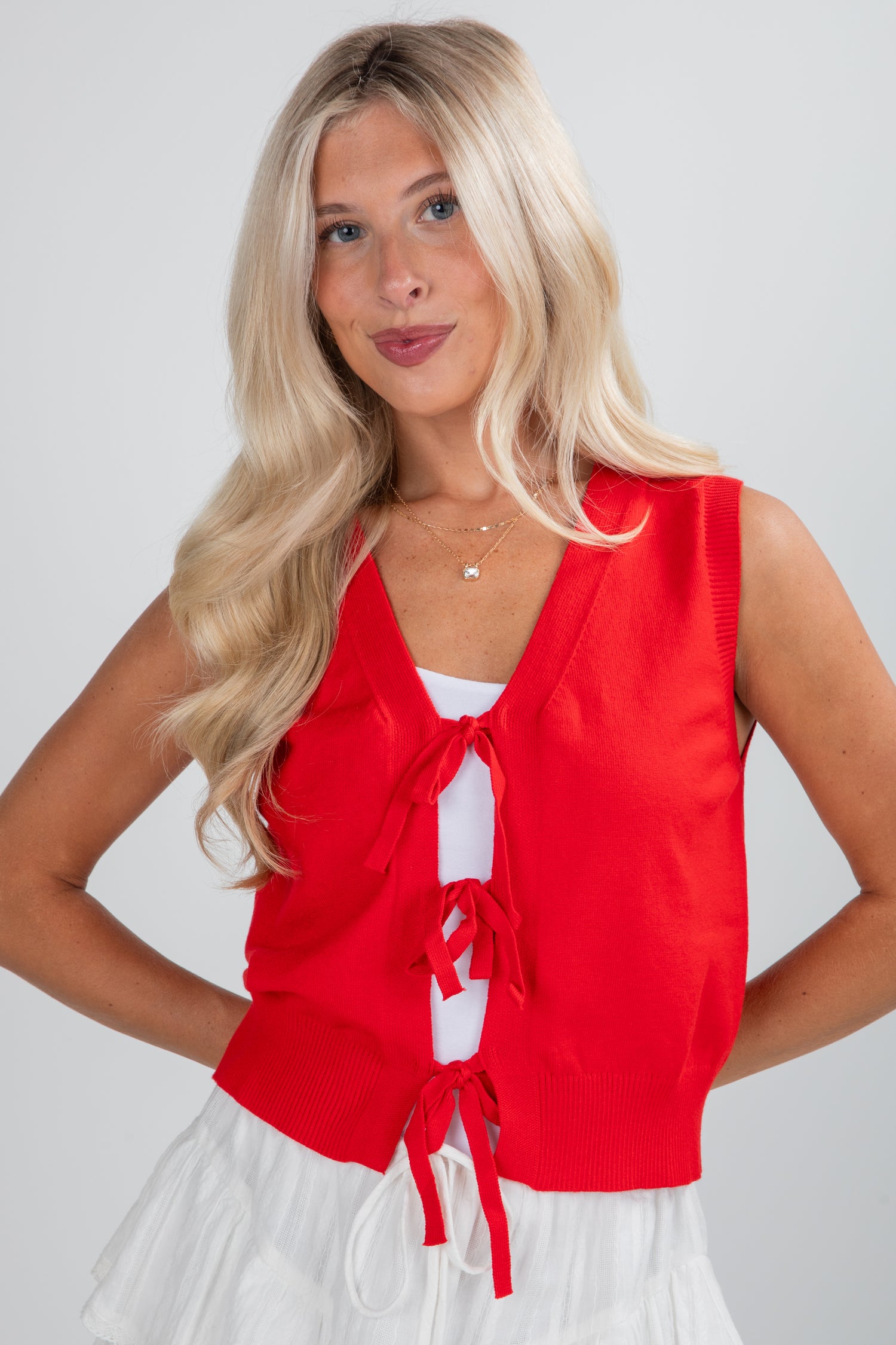 Woman wearing a red sleeveless top with a white background