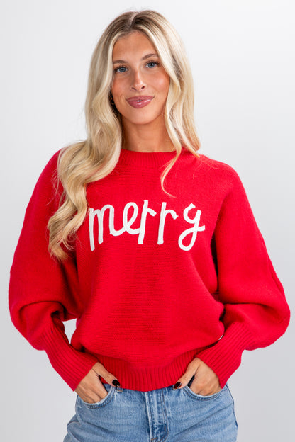 Woman wearing a red sweater with &