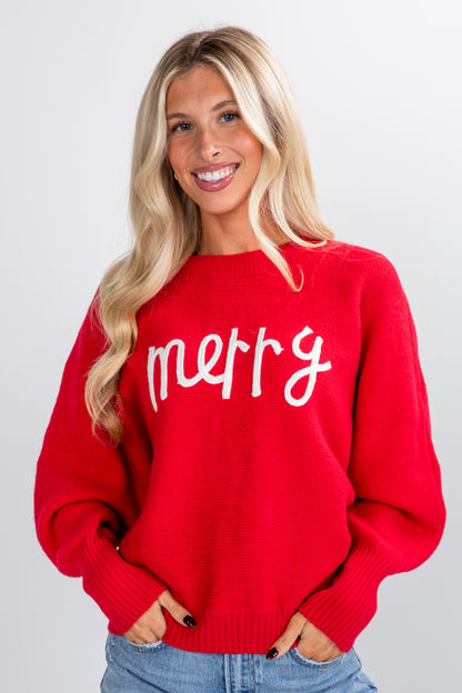 Woman wearing a red sweater with &