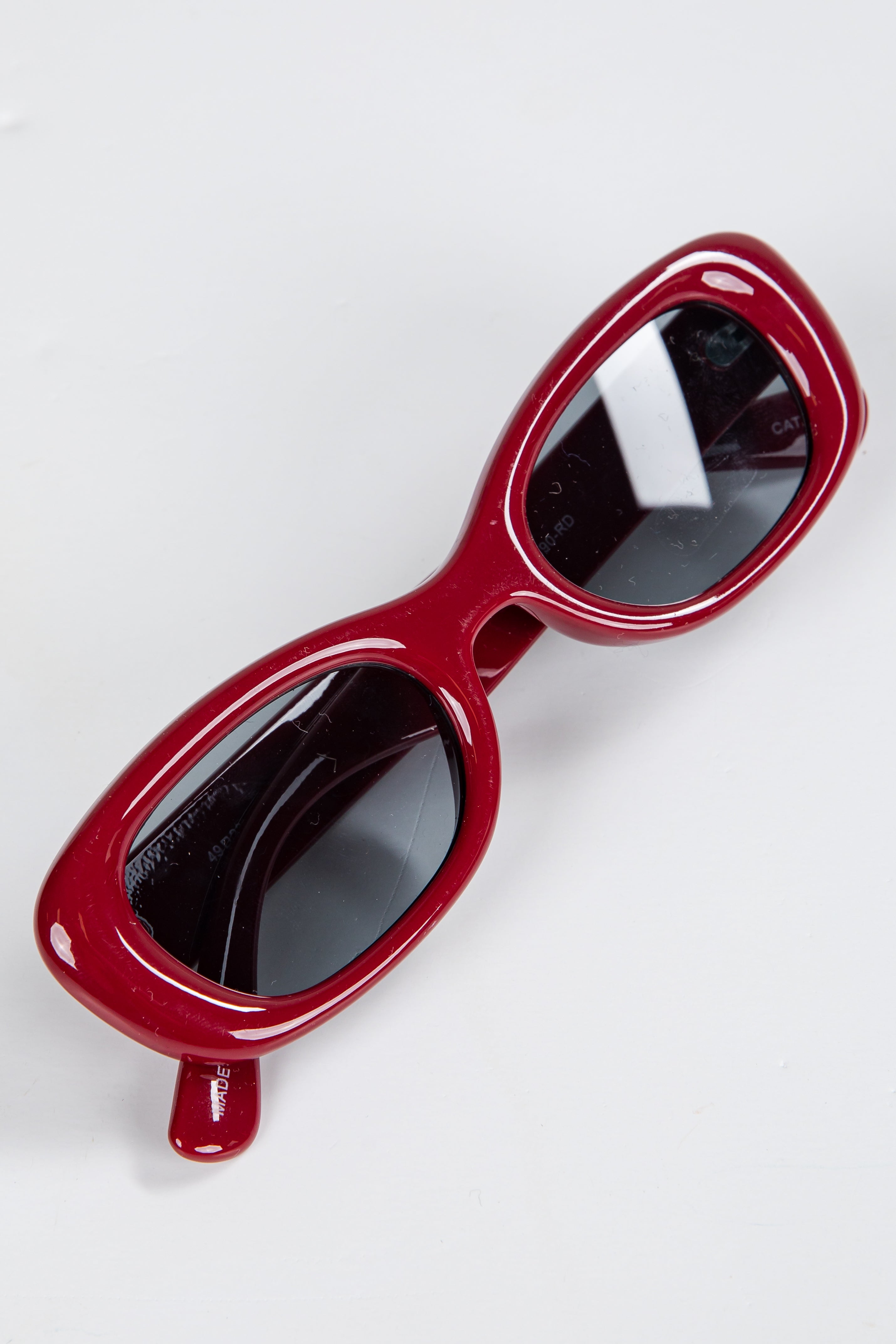 Red sunglasses with black lenses on a white background