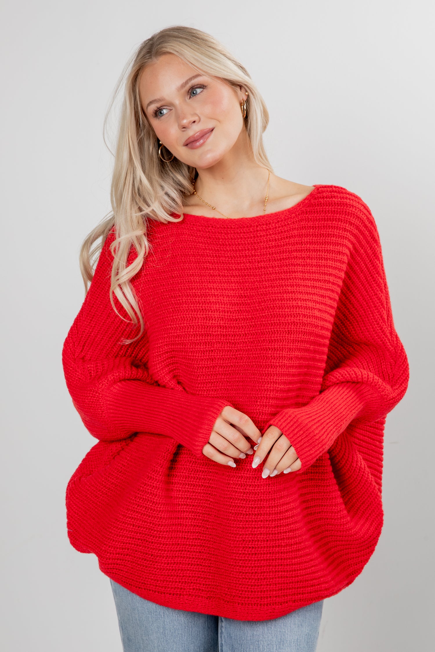 Woman wearing a red sweater against a plain background
