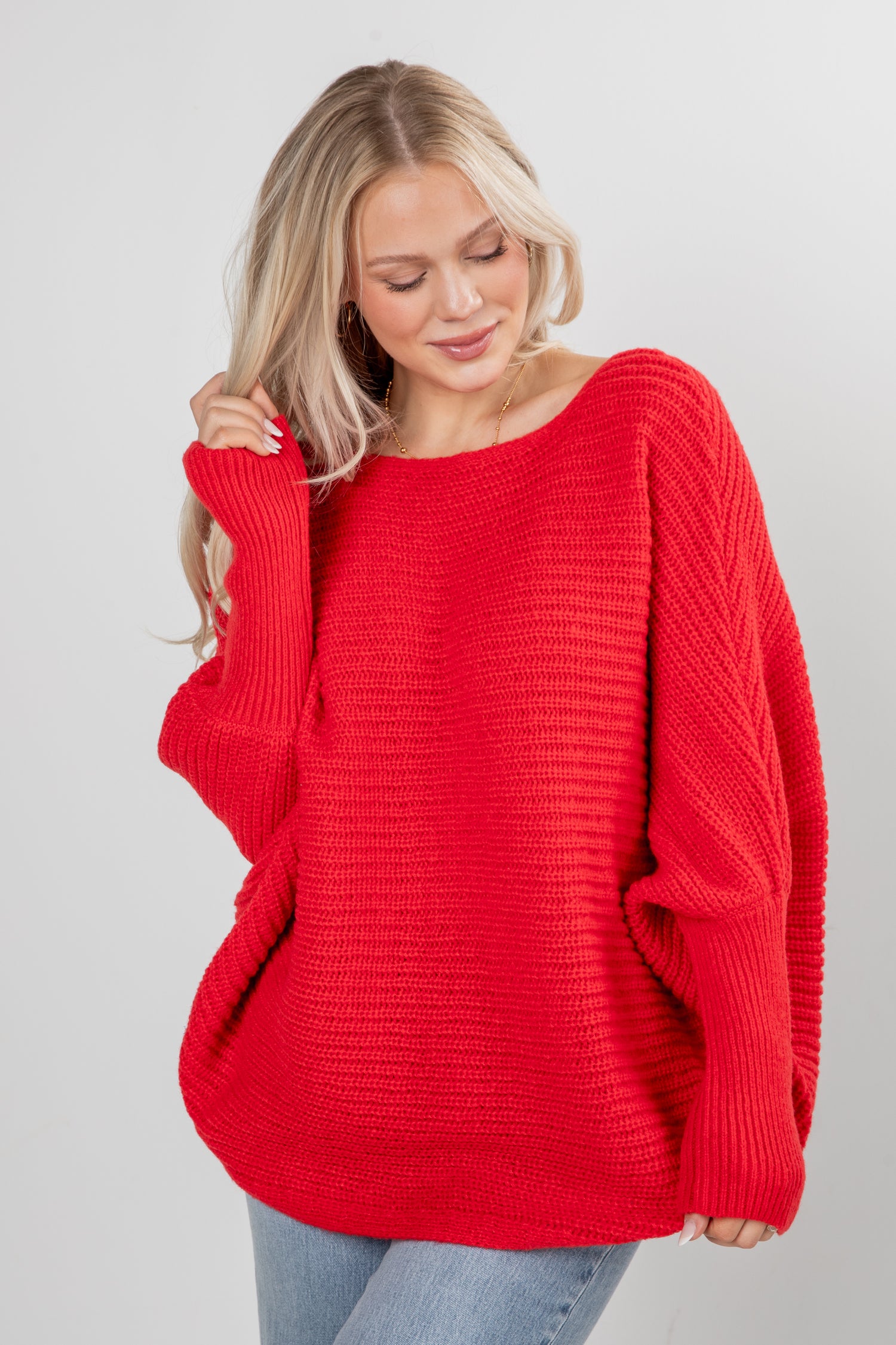 Woman wearing a red sweater against a gray background