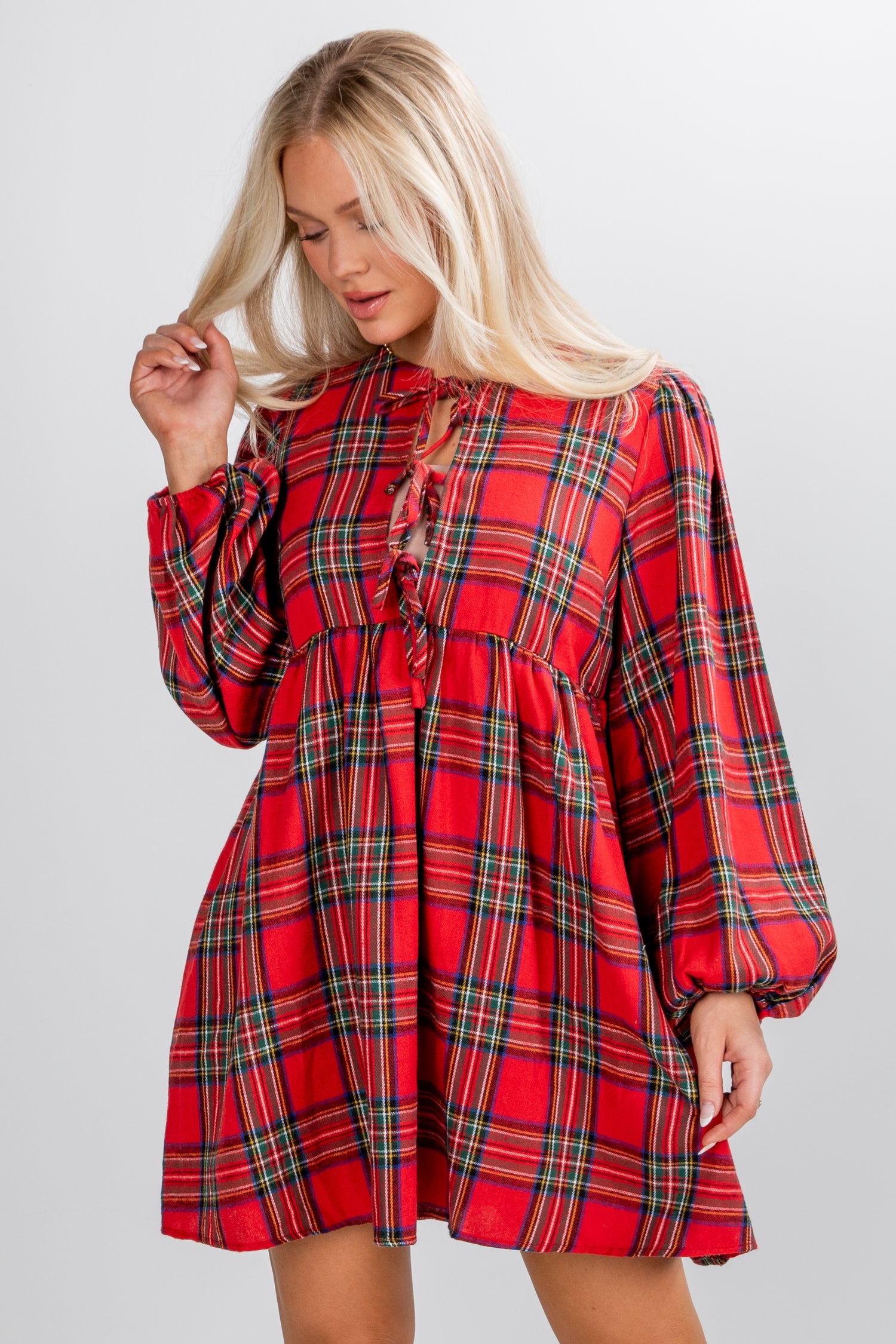 Woman wearing a red plaid dress on a gray background