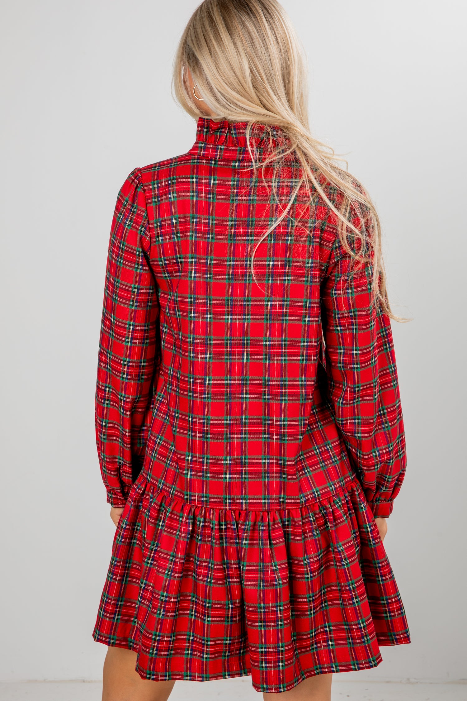 Red plaid dress worn by a person with a plain background