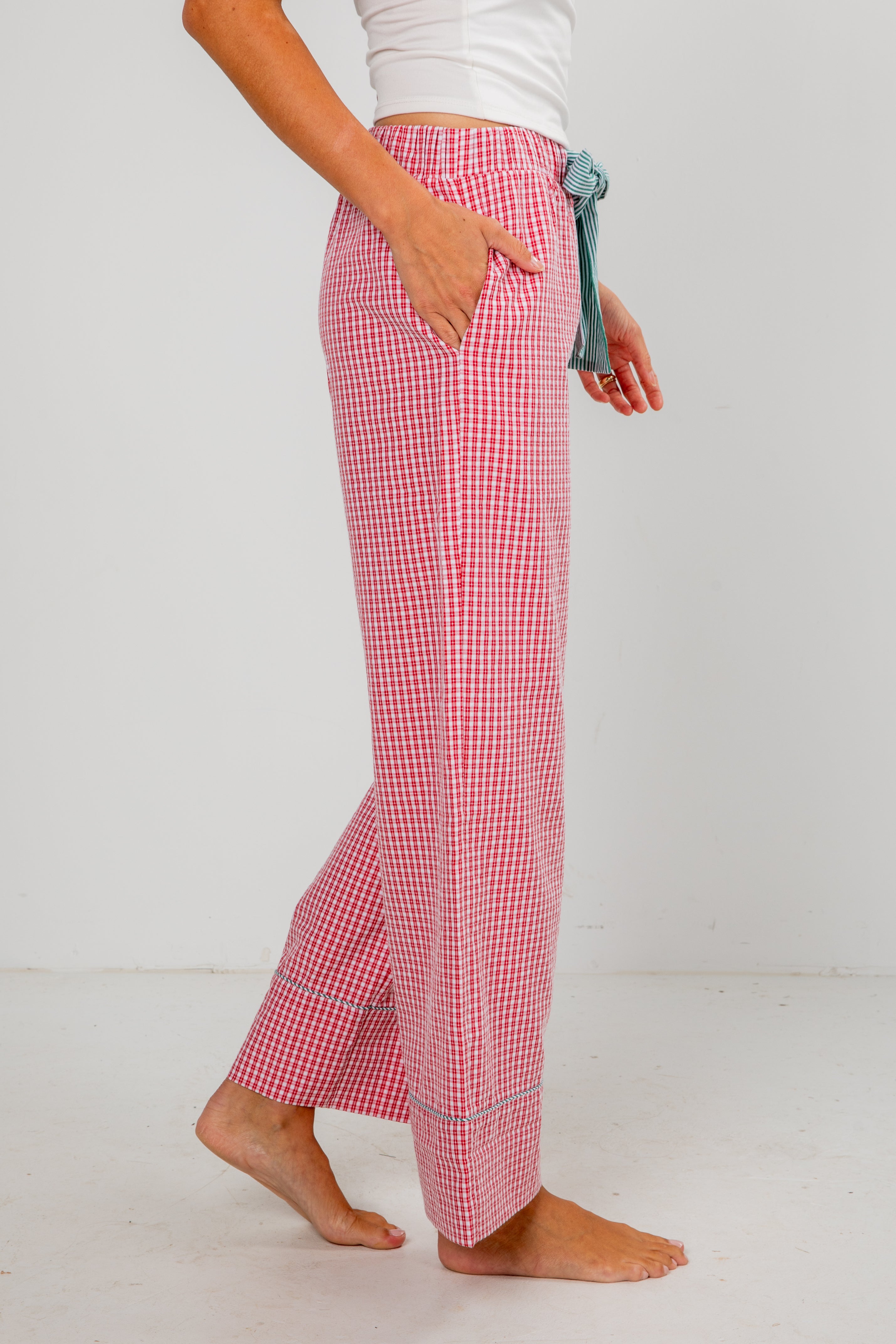 Person wearing red checkered pants on a white background