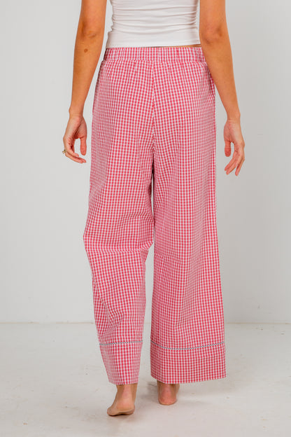 Person wearing red and white checkered pants on a white background