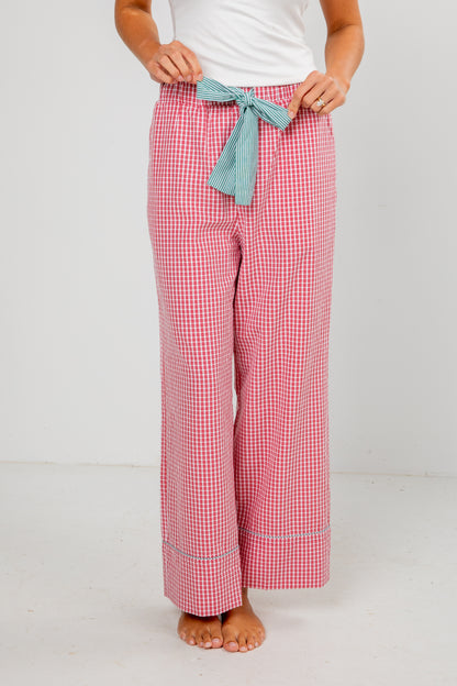 Red checkered pajama pants with a blue ribbon on a white background