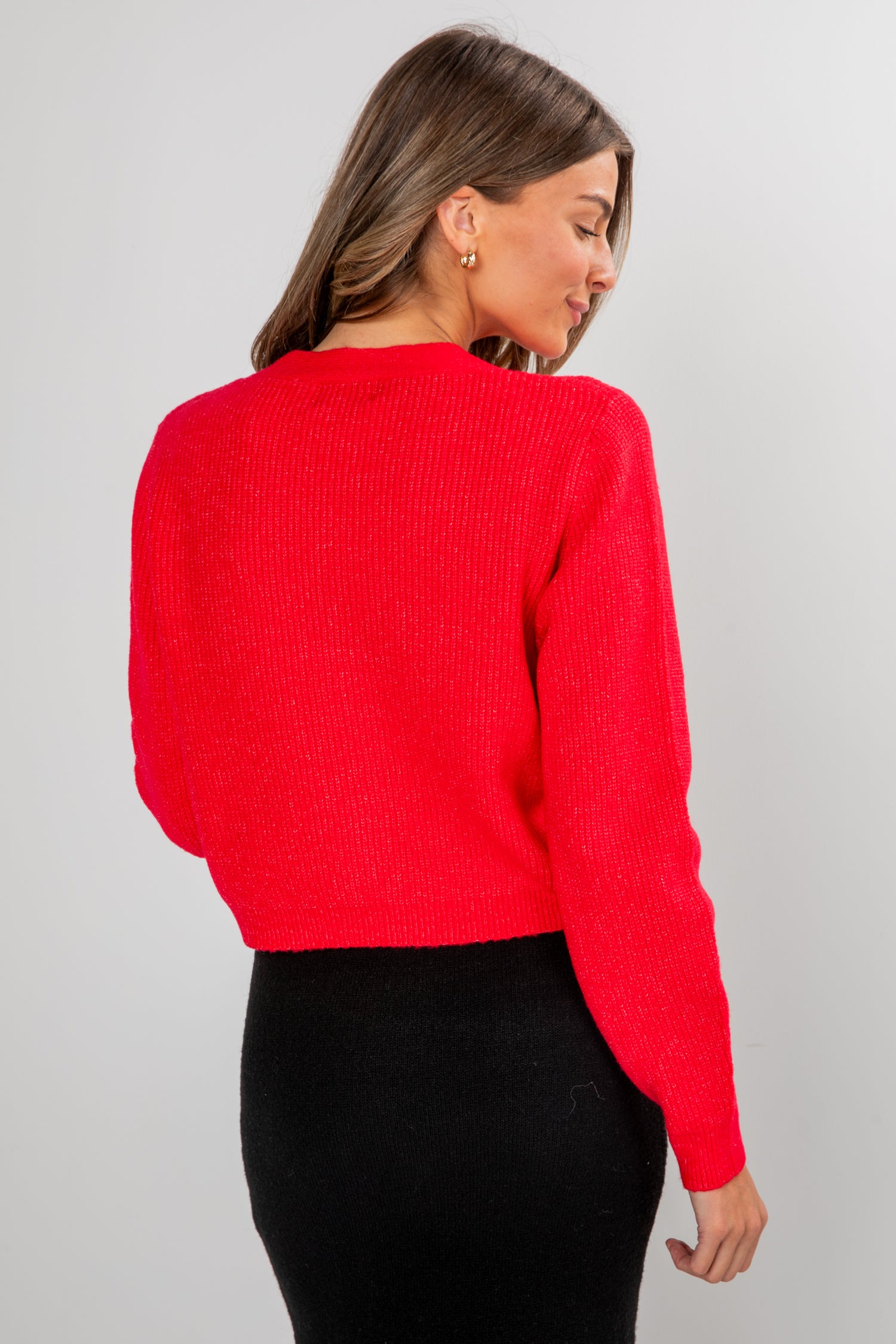 Woman wearing a red sweater against a gray background