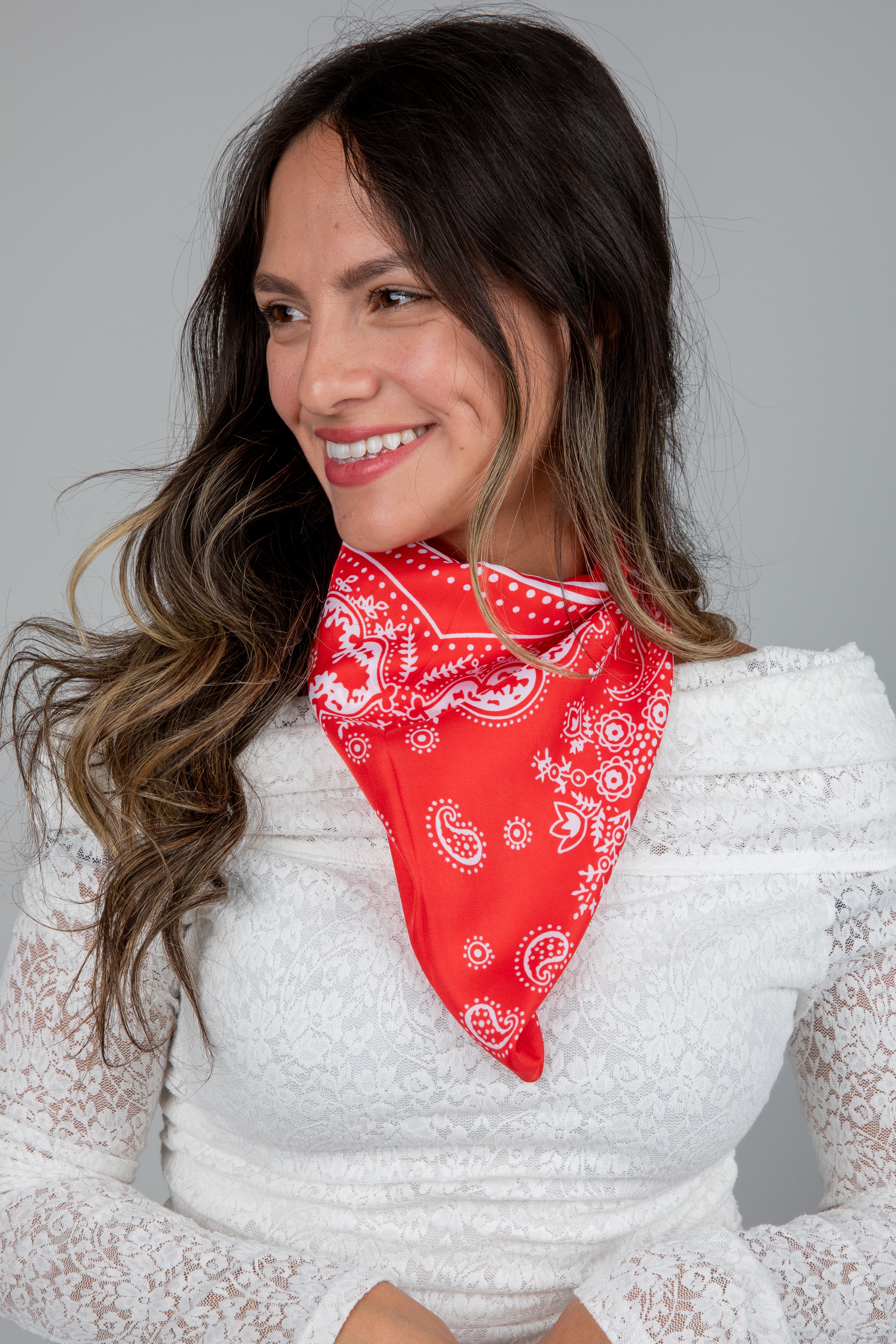 Woman wearing a red bandana with white patterns on a plain background