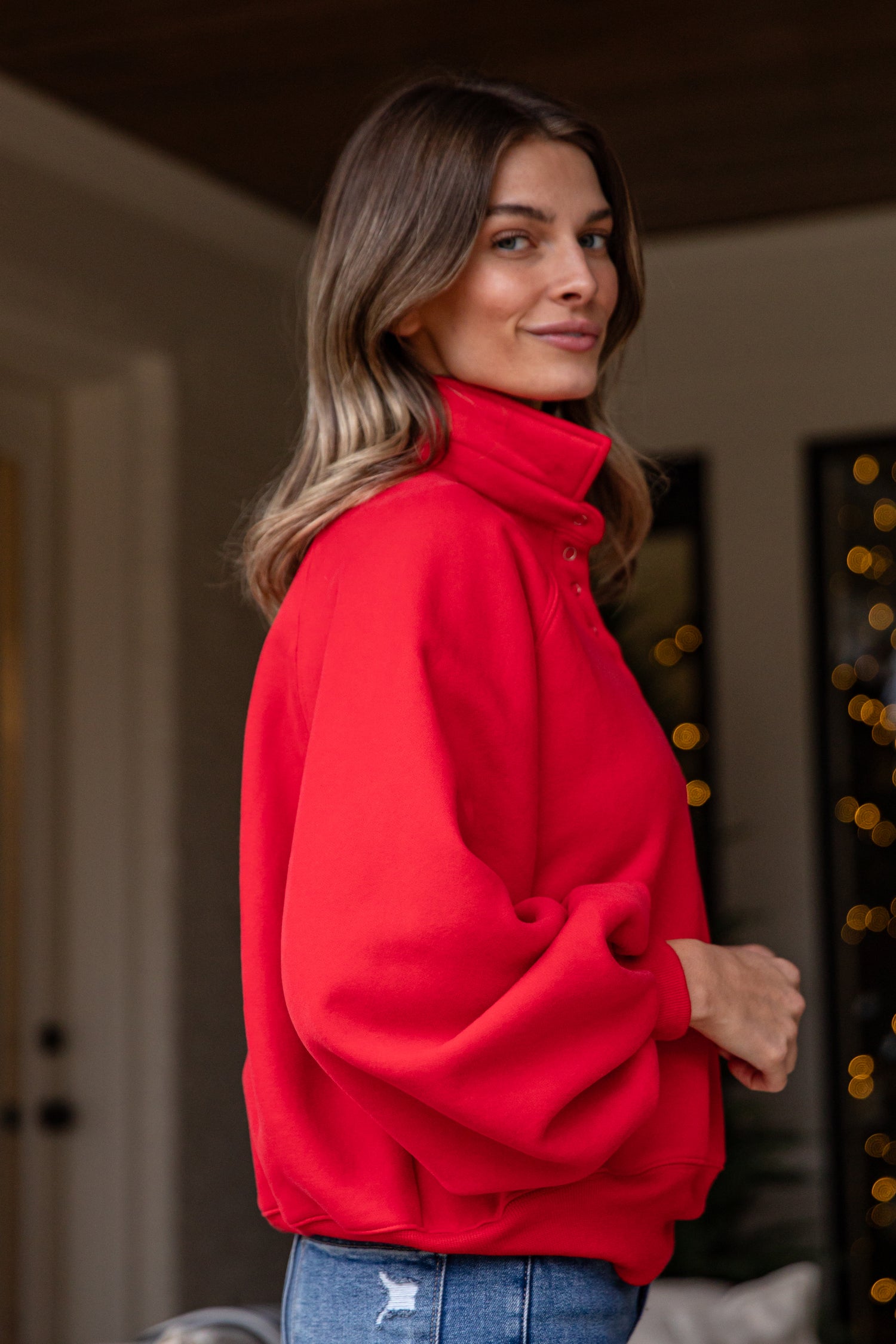 Woman wearing a red jacket indoors with blurred background