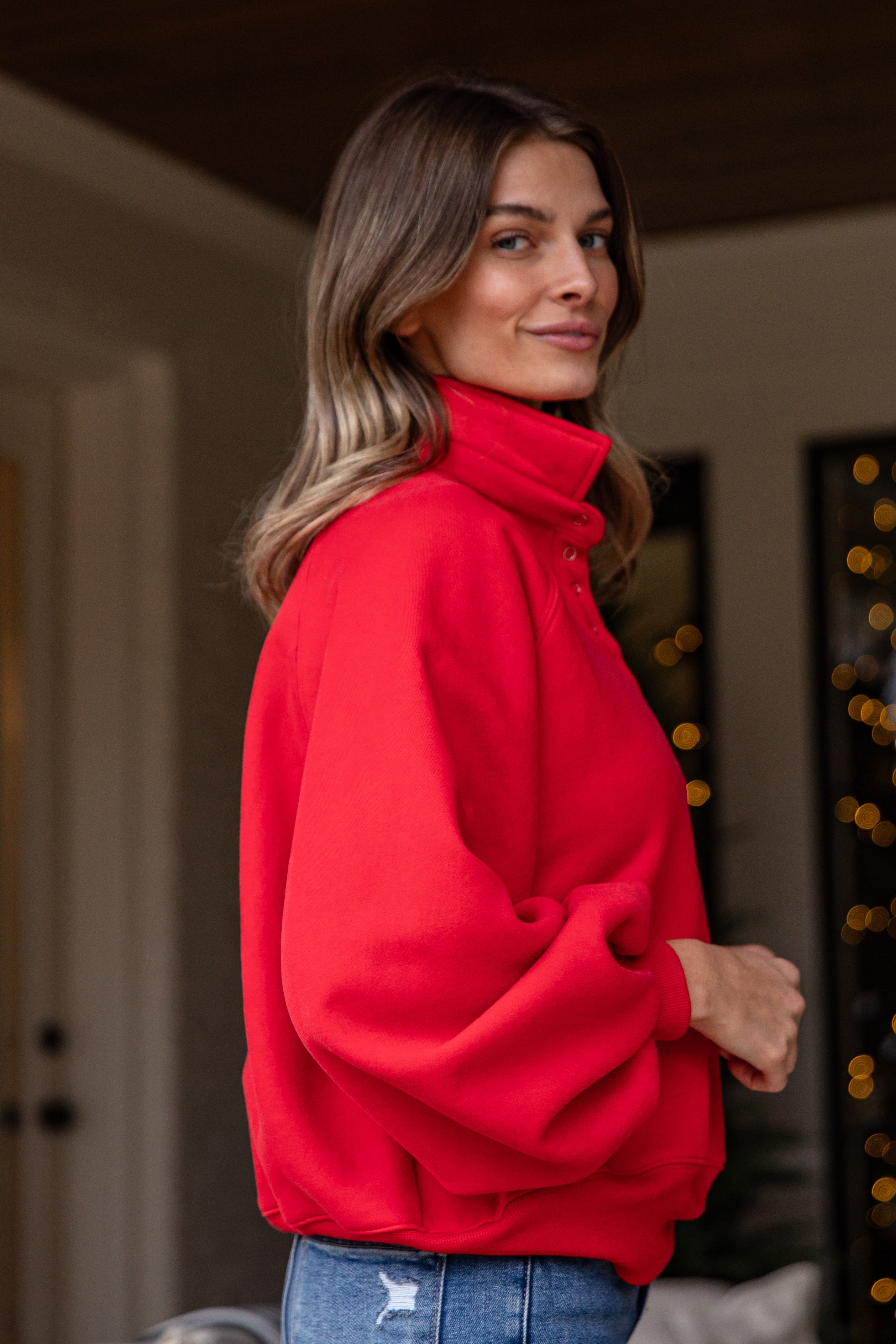 Woman wearing a red jacket indoors with blurred background