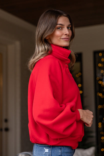 Woman wearing a red jacket indoors with blurred background
