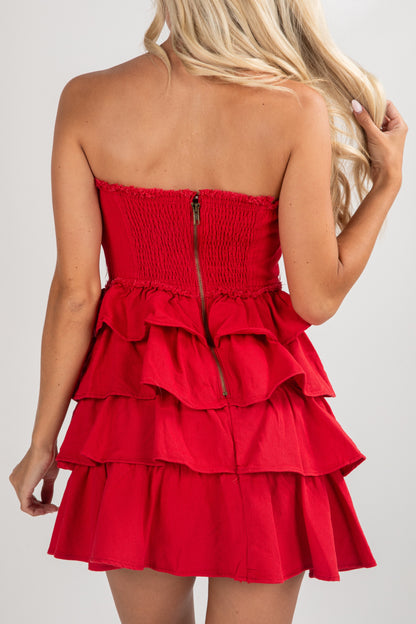 Red strapless dress with ruffled layers on a white background