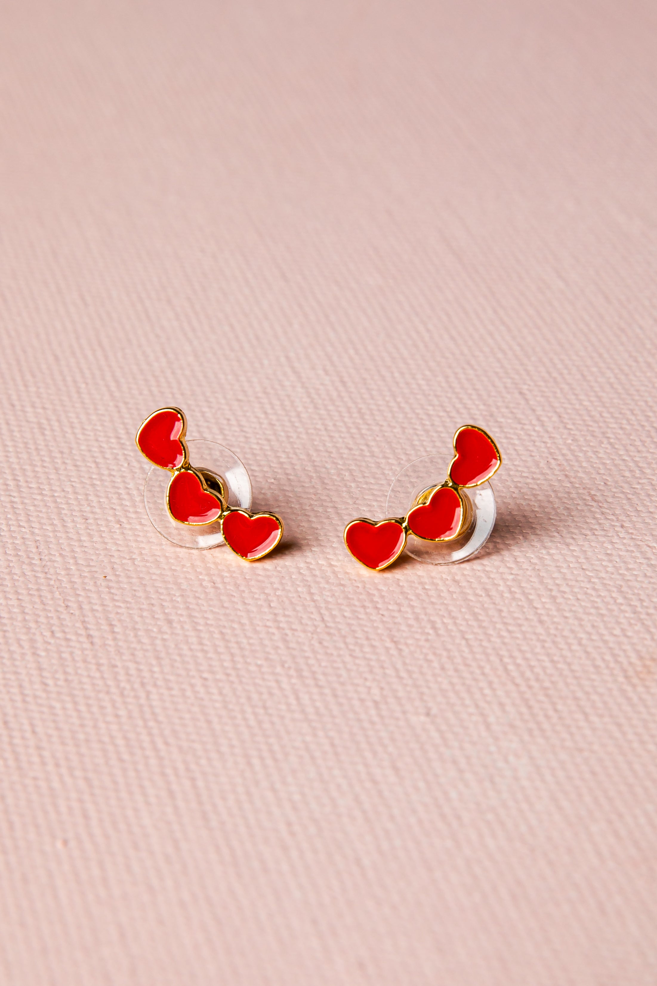 Heart-shaped earrings on a pink background
