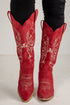 Red cowboy boots with white embroidery on a white background