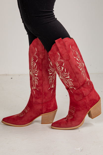 Red cowboy boots with white embroidery on a white background