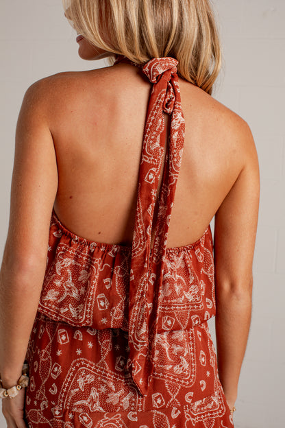 rust mini dress features an ivory paisley print, a flattering halter neckline, and a flowy silhouette