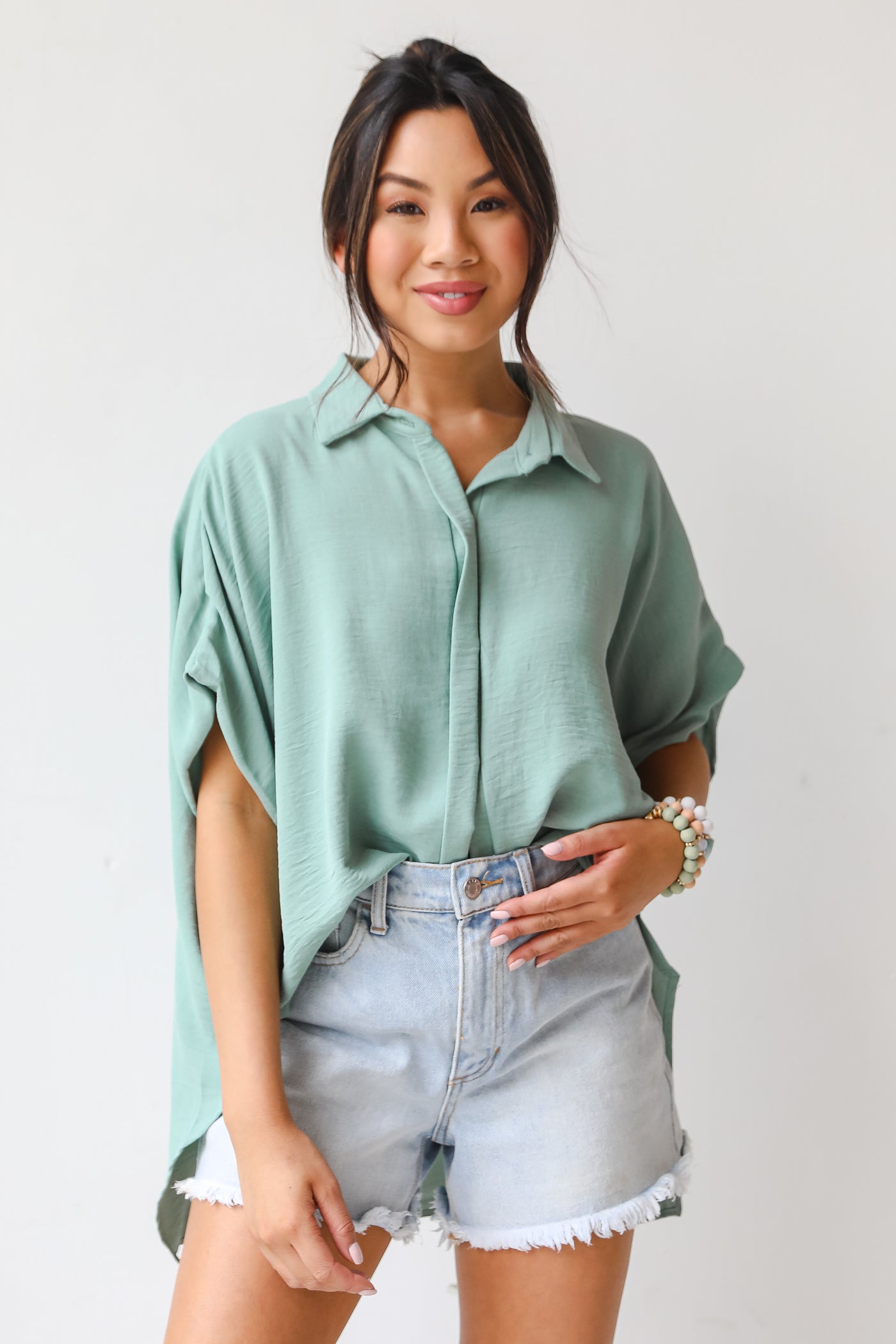 model wearing a sage Button-Up Blouse