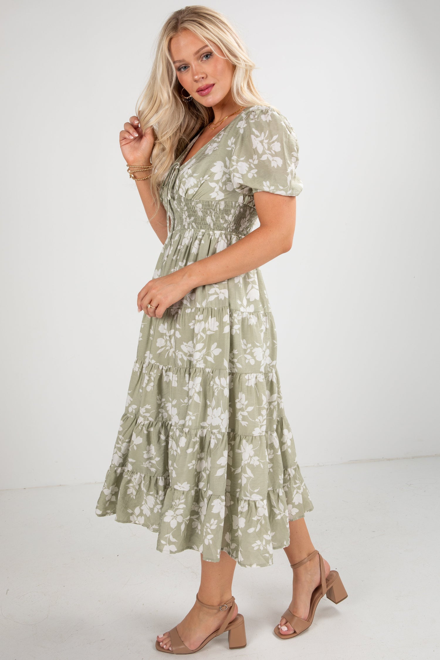 Woman wearing a green floral dress on a white background