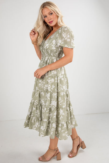 Woman wearing a green floral dress on a white background