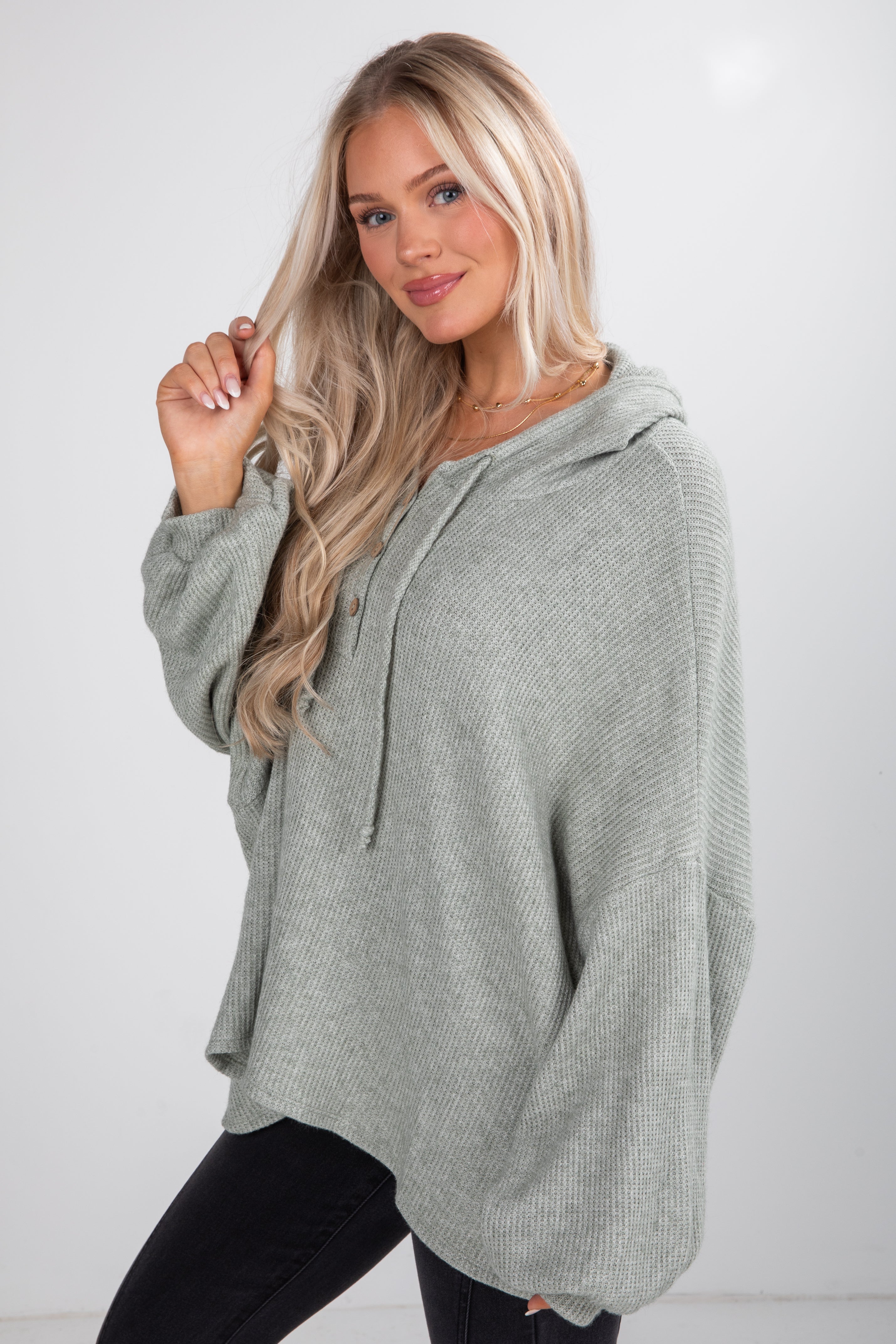 Woman wearing a gray hoodie against a white background