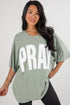 Woman wearing a green oversized t-shirt with &