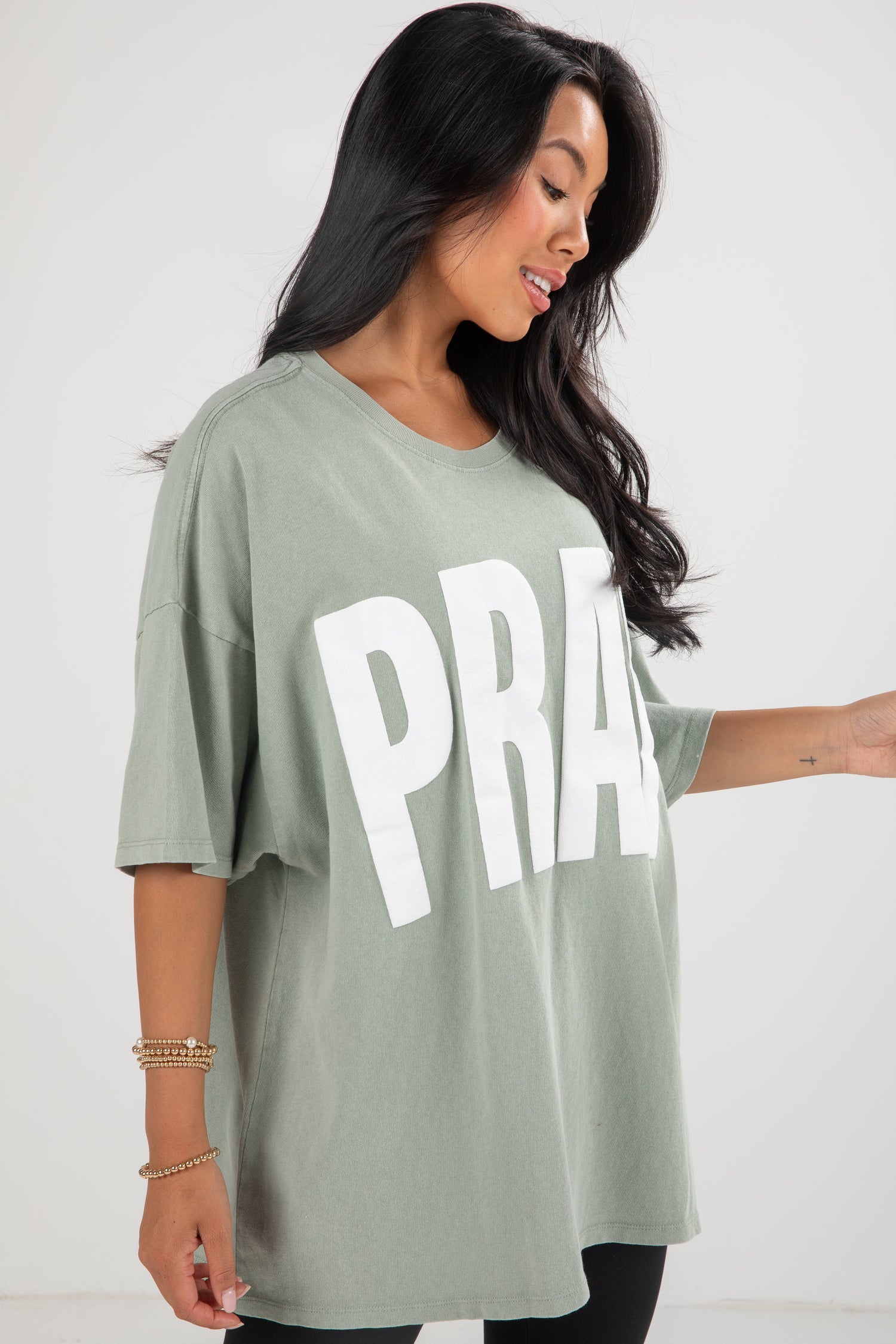 Woman wearing a green t-shirt with &