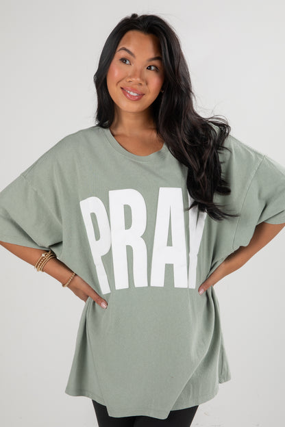 Woman wearing a green oversized t-shirt with &