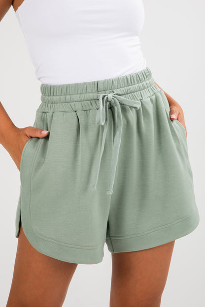 Green shorts with a drawstring waist on a white background