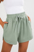 Green shorts with a drawstring waist on a white background