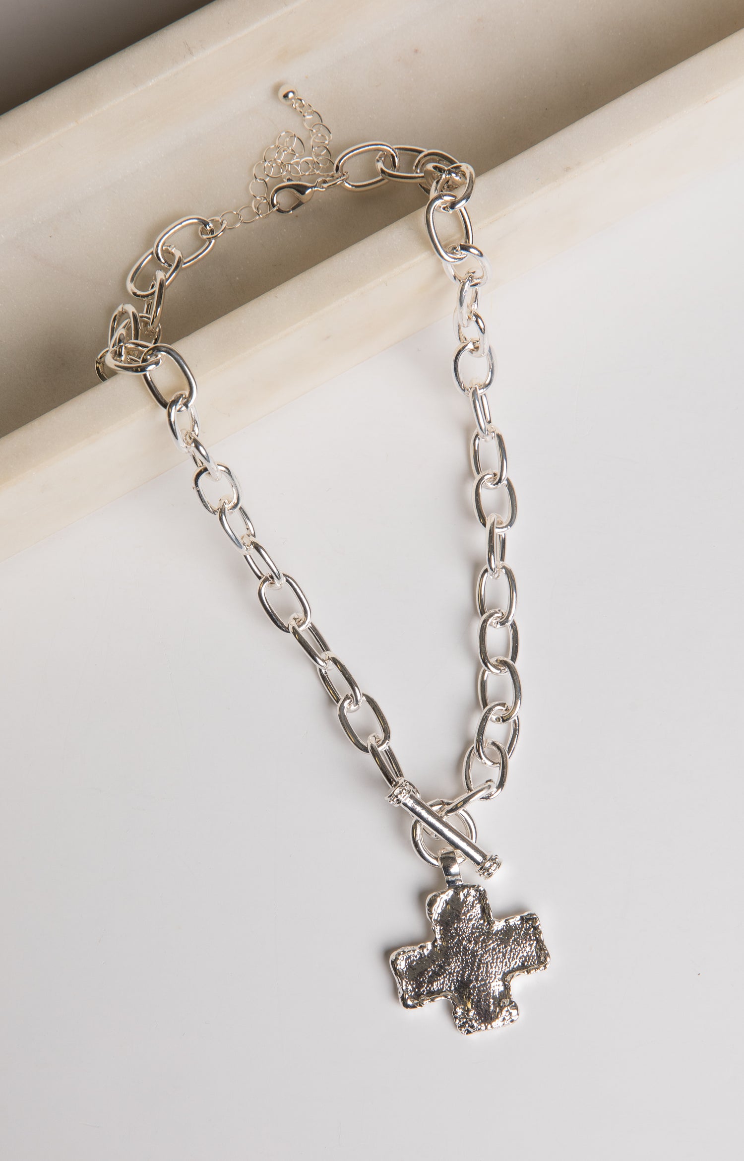 Silver chain bracelet with a paw print charm on a light background