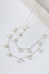 Silver necklace with small pearls on a light background