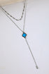 Necklace with a blue flower pendant on a white surface