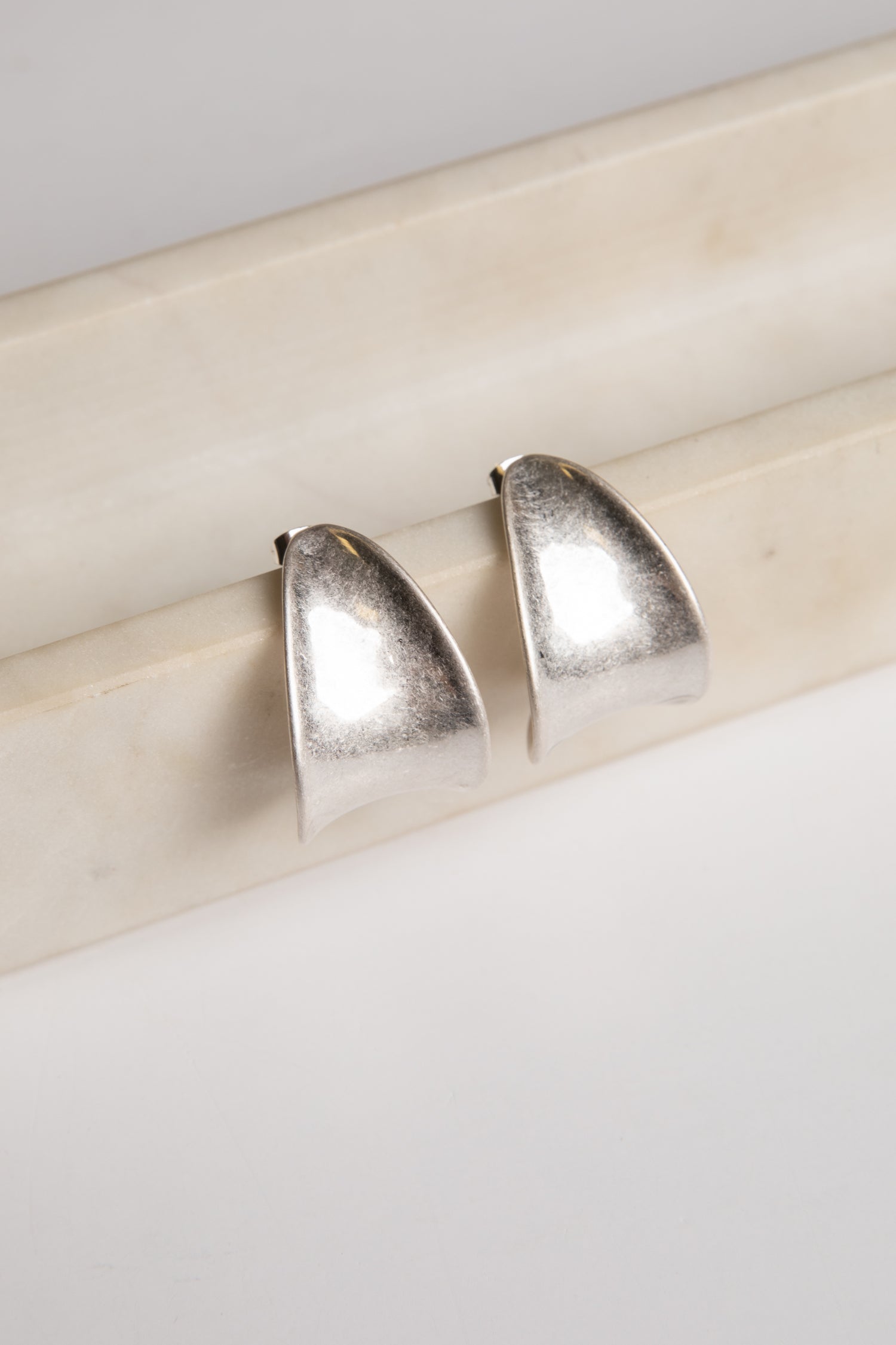 Pair of silver earrings on a light wooden surface