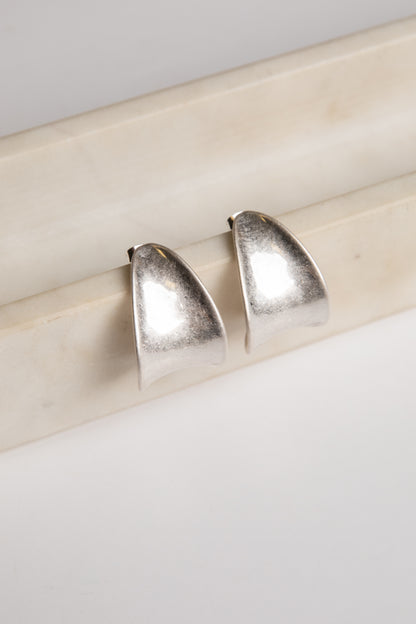 Pair of silver earrings on a light wooden surface