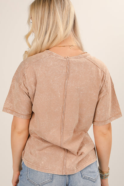 Person wearing a brown short-sleeve top with a beige background