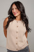 A woman wearing a sleeveless ribbed knit cardigan vest in a light beige color with brown buttons, paired with gray jeans, photographed against a neutral light gray background.