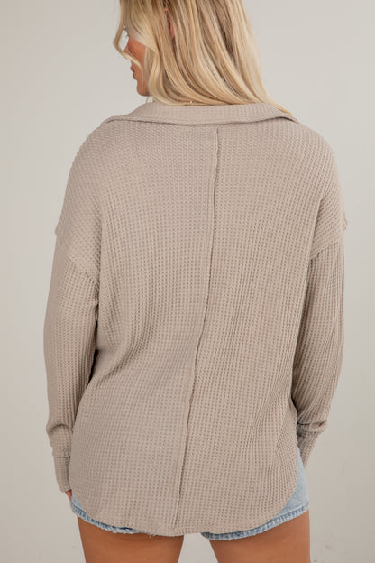 Beige textured shirt worn by a person on a plain background