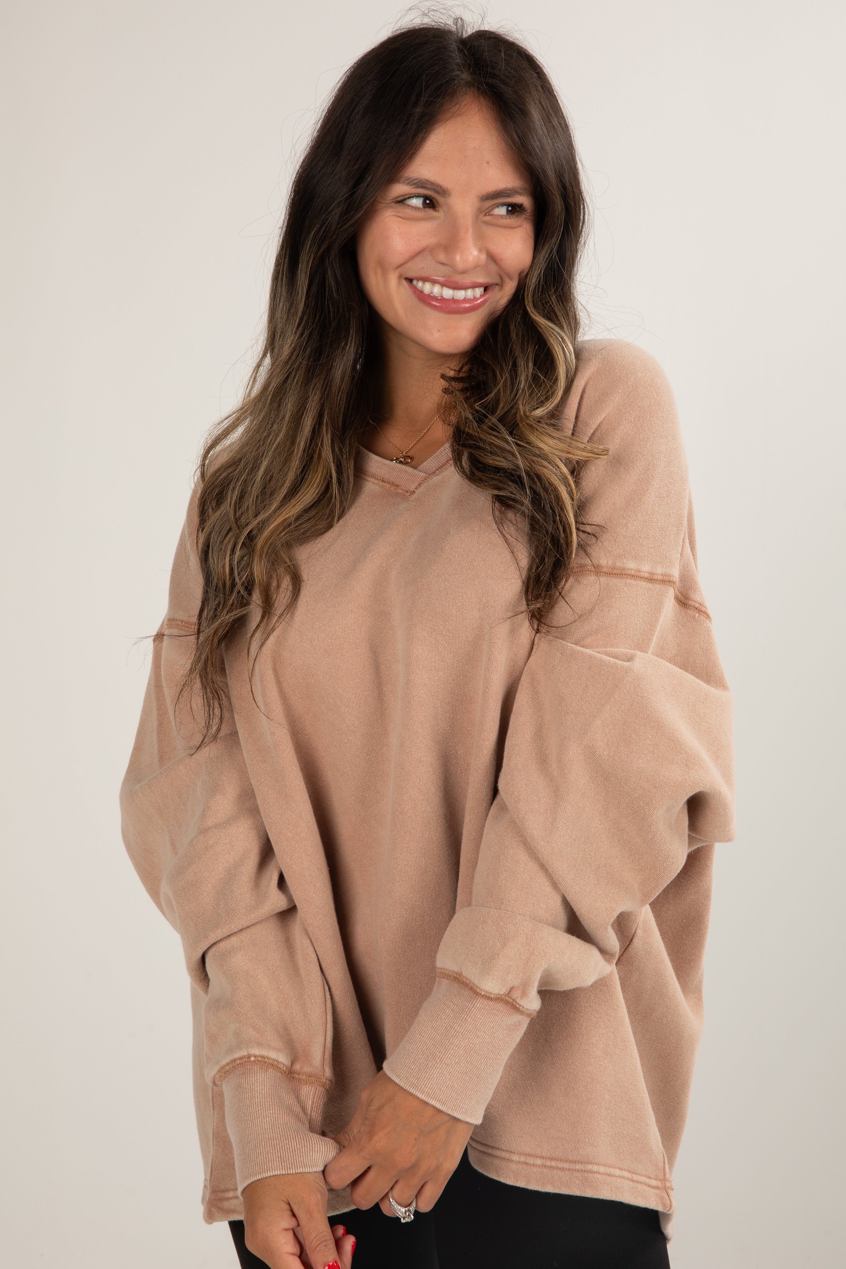 Woman wearing a beige sweater against a white background