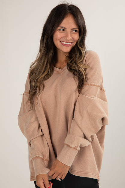 Woman wearing a beige sweater against a white background