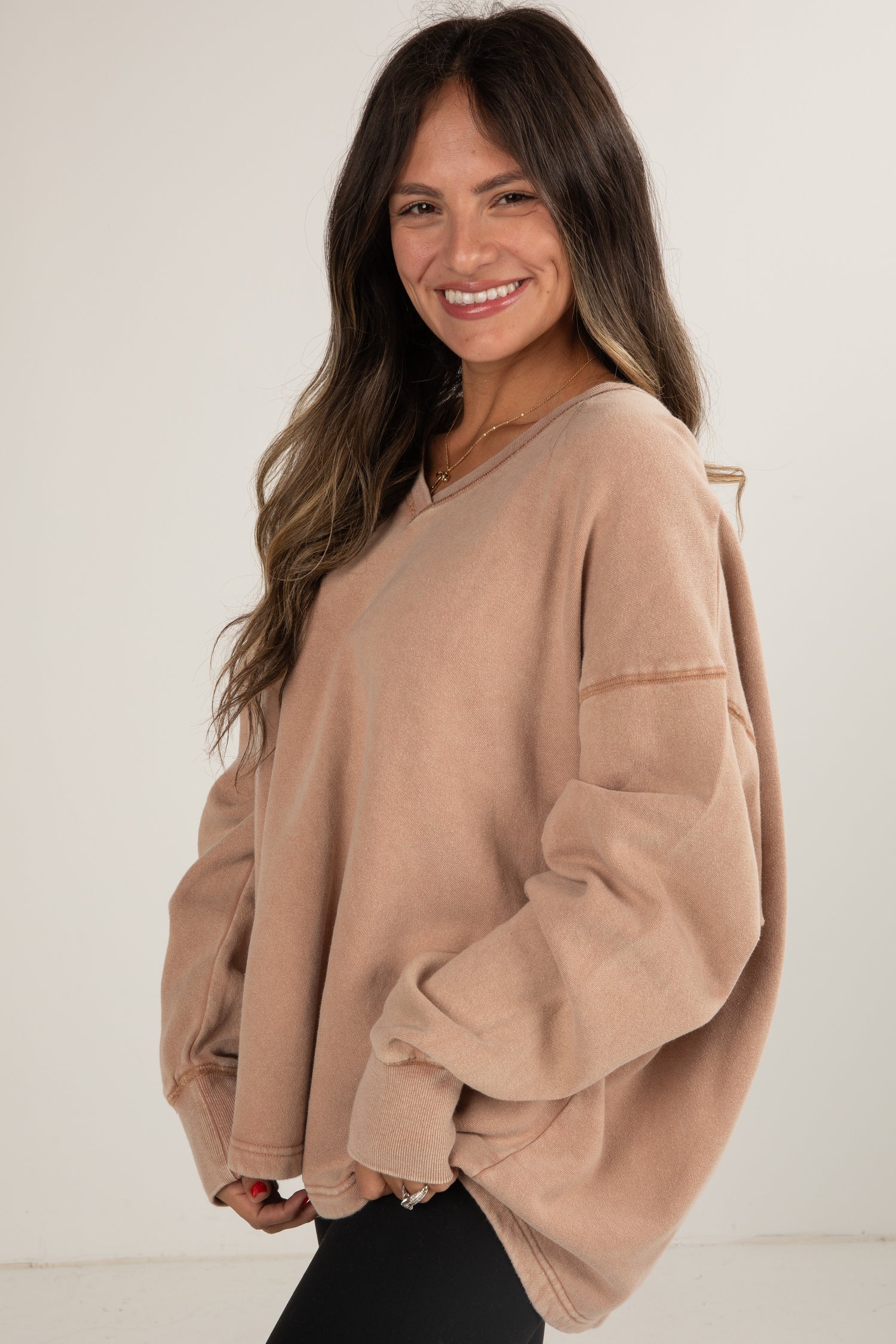 Woman wearing a beige sweater against a white background
