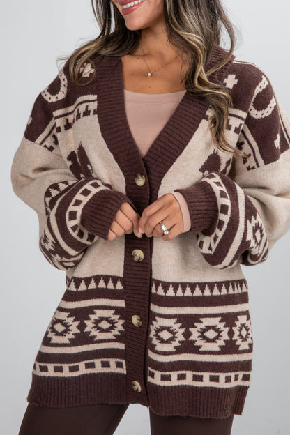 Person wearing a patterned cardigan with a neutral background