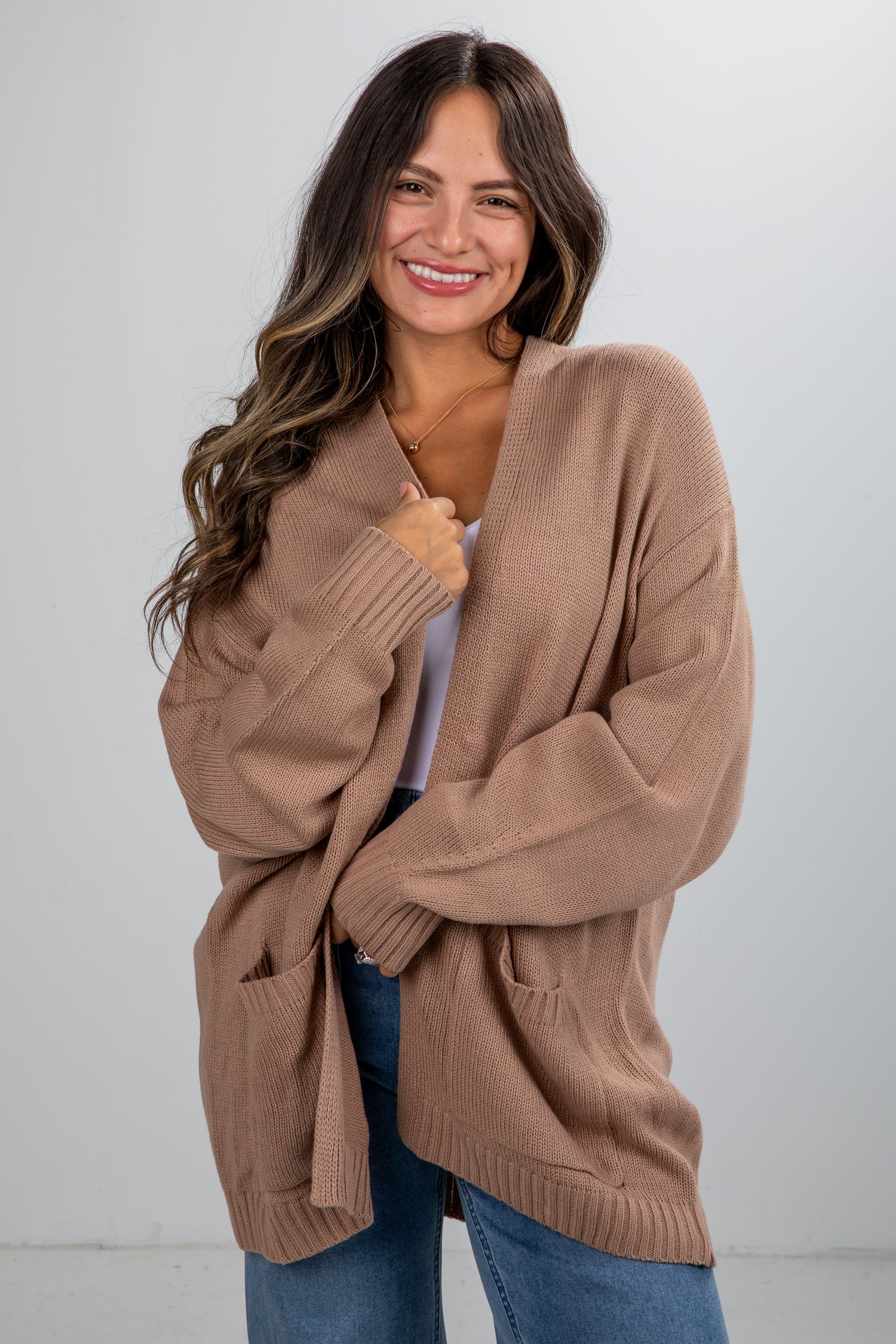 Woman wearing a brown cardigan against a white background