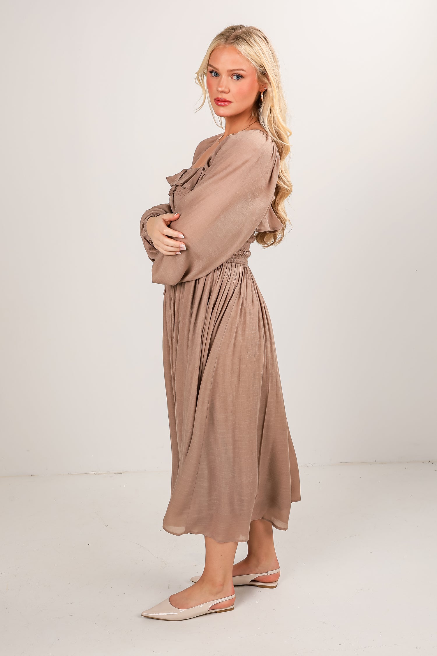 Woman wearing a beige dress on a white background