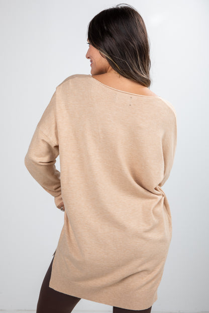 Woman wearing a beige sweater against a white background