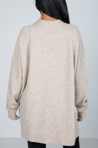 Beige cardigan worn by a person on a plain background