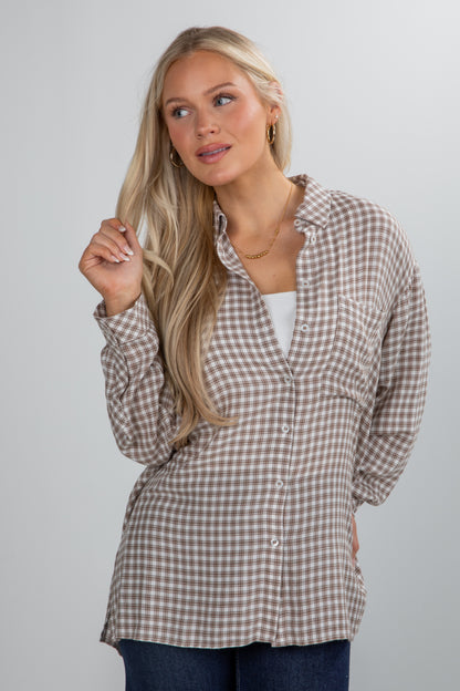 Woman wearing a plaid shirt against a plain background