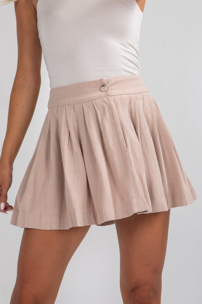 Beige skirt worn by a person on a plain background