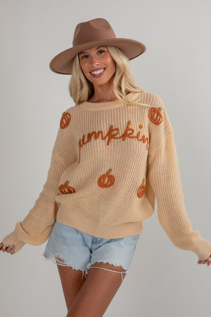 Woman wearing a beige sweater with &