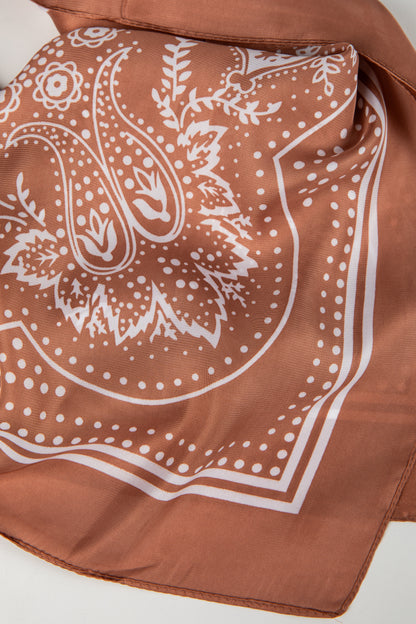 Brown bandana with white paisley pattern on a white background